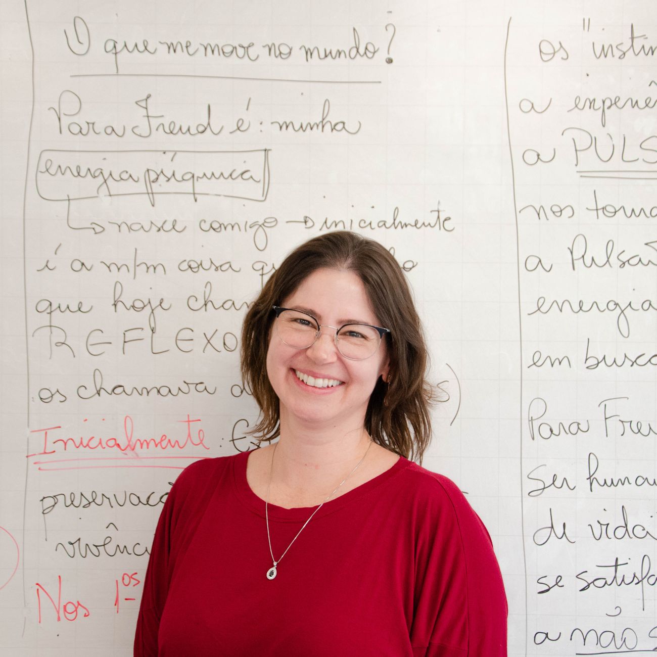 Teacher standing by a classroom whiteboard, part of the daily documented routine.